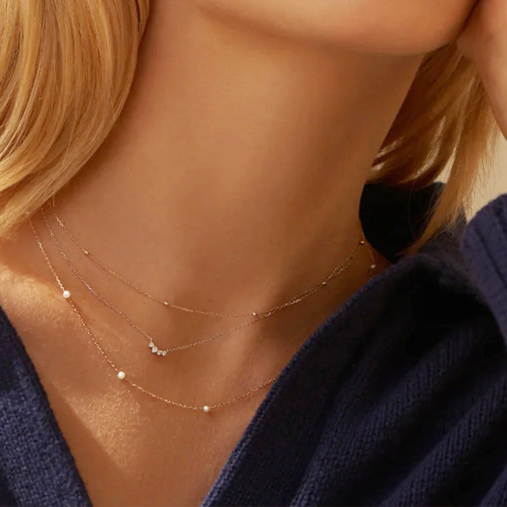A layered look featuring the 3mm small pearl necklace with other gold chains.