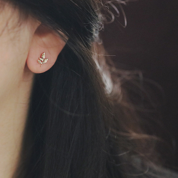 Model wearing the gold maple leaf stud earring to show its scale and appearance.