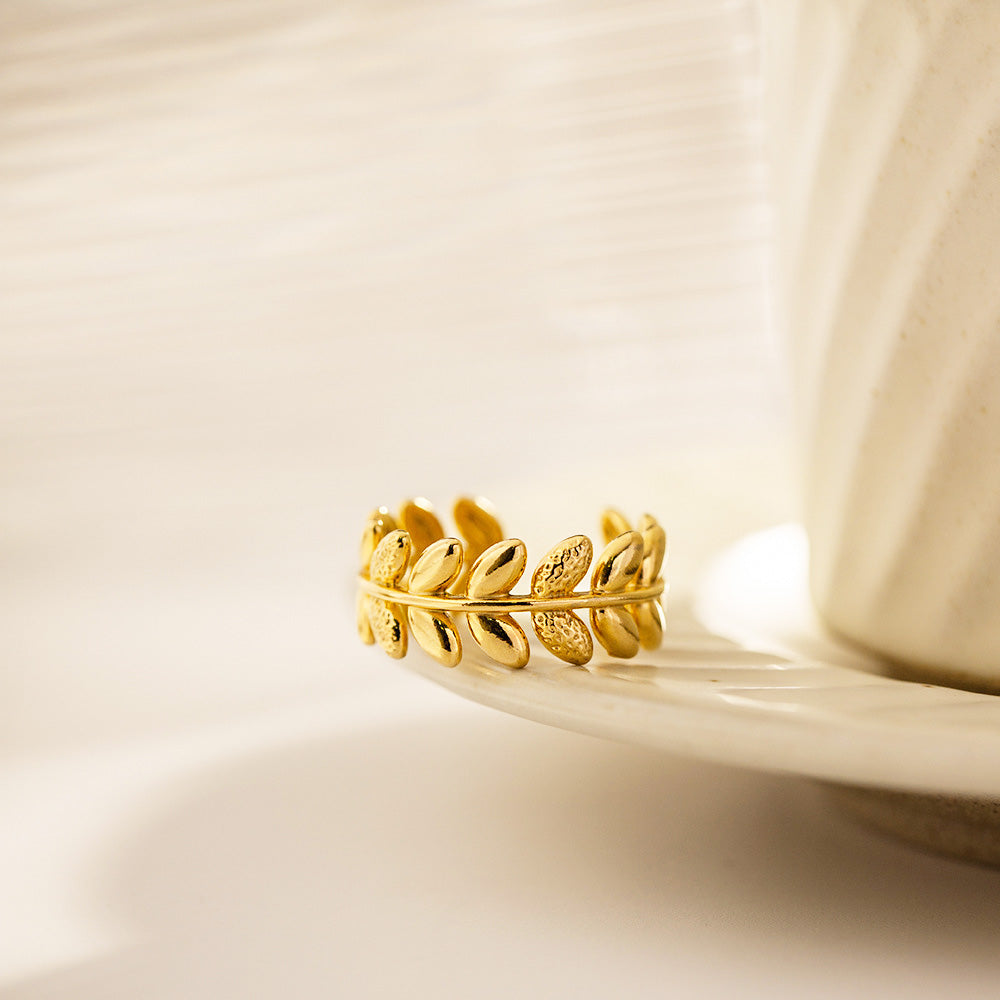 A detailed close-up of the gold olive branch leaf ring's texture.
