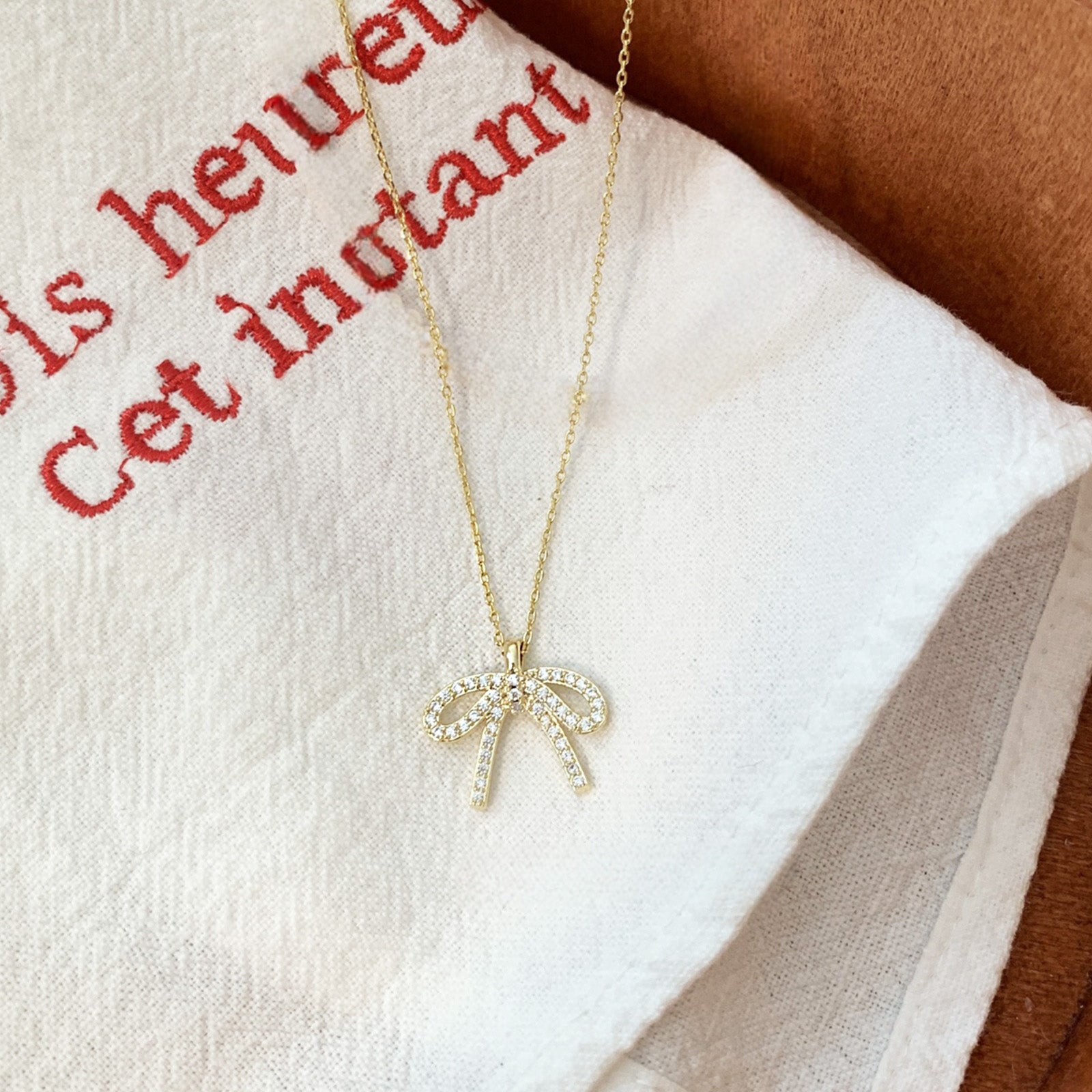 Detailed view of the zircon stones on the 925 sterling silver bow-knot pendant.