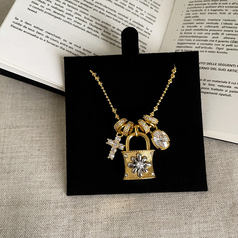 Close-up of the gold plated padlock charm with zircon accents on a brass chain necklace.