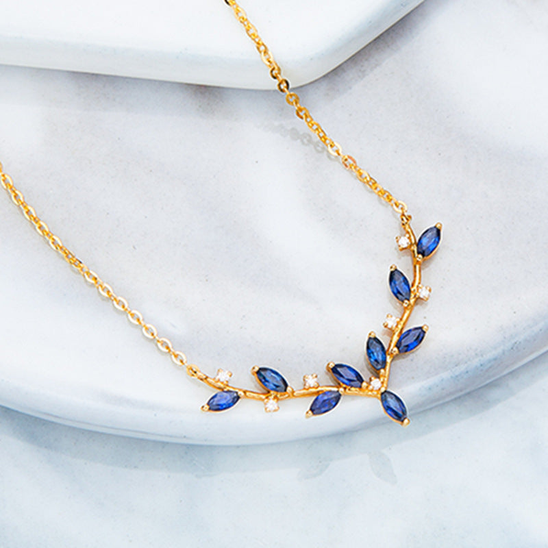 A detailed view of the blue gemstone leaf pendant on the 925 sterling silver necklace