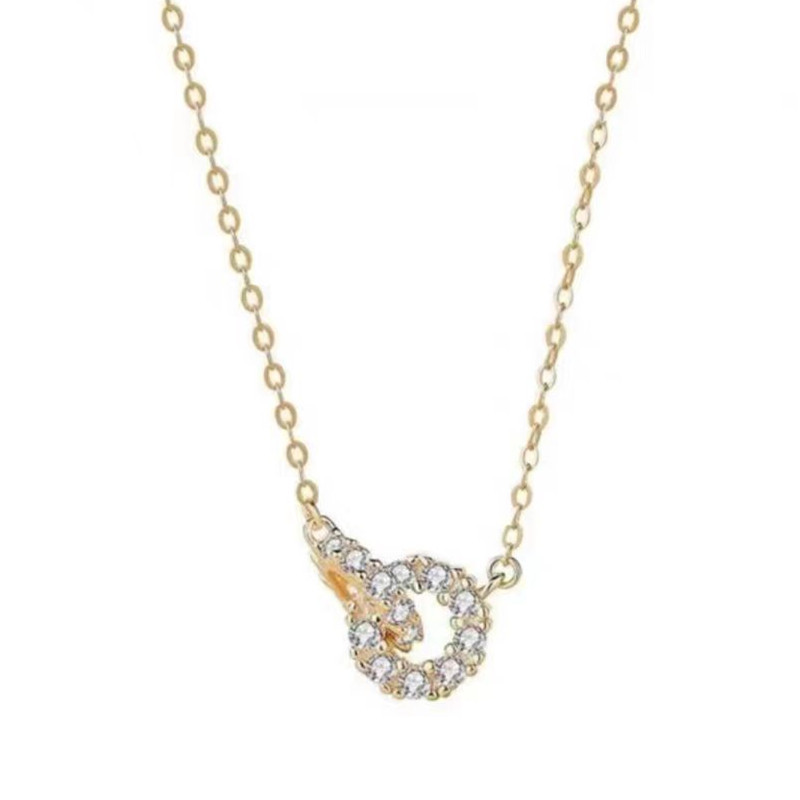 Detailed view of the gold double circle pendant with clear gemstones