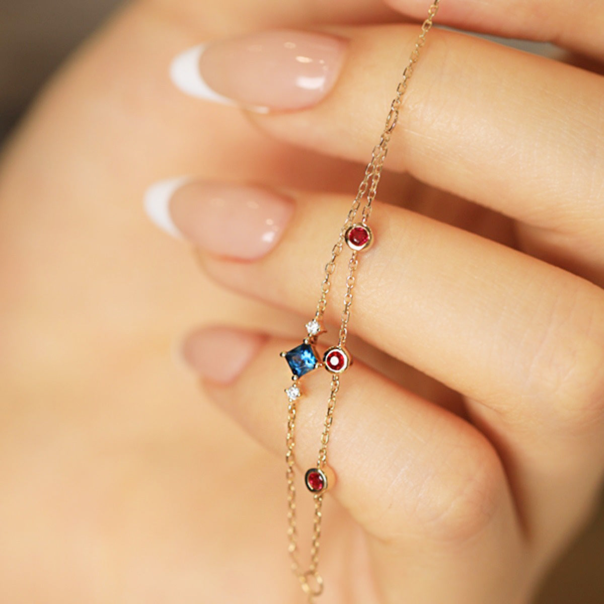 A detailed view of the double-strand design of the 925 sterling silver bracelet with a blue square-cut zircon.