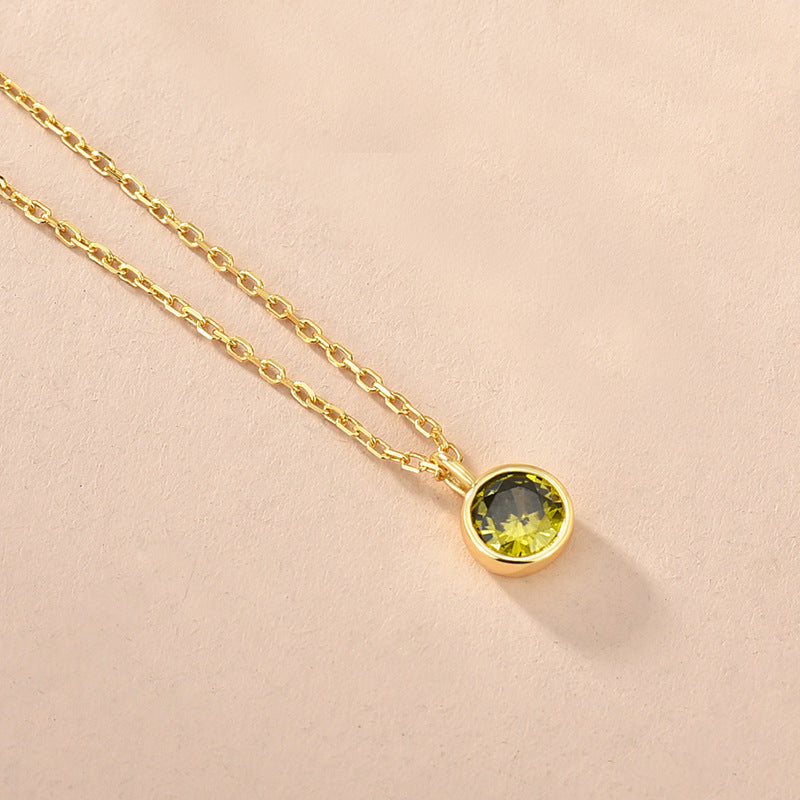 A close-up of the zodiac birthstone necklace with a green gem