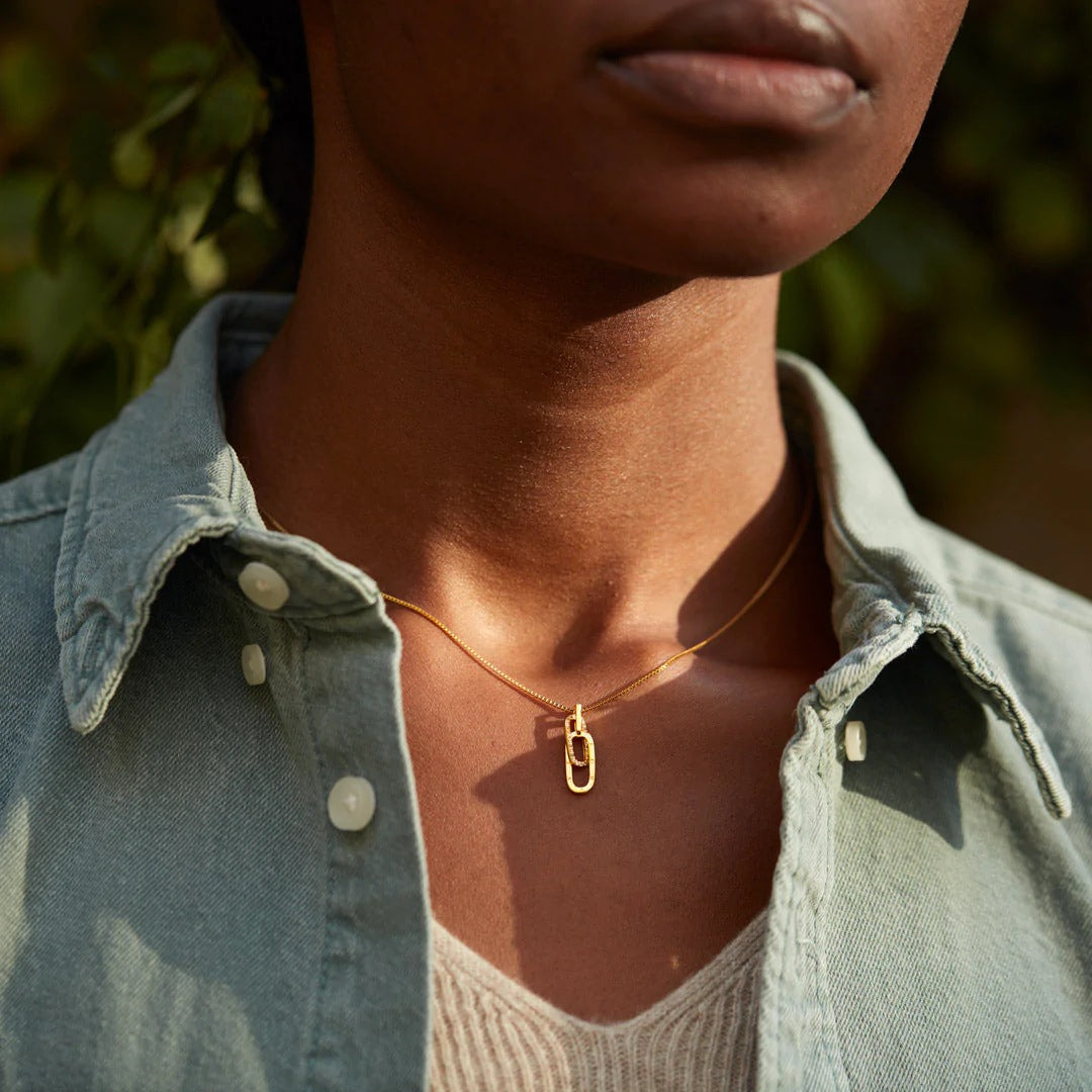 Model showcasing the gold interlocking zircon pendant necklace