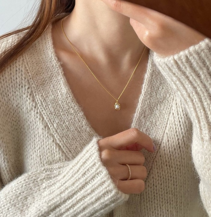 A close-up of the gold-plated pearl necklace showing its fine details and craftsmanship.