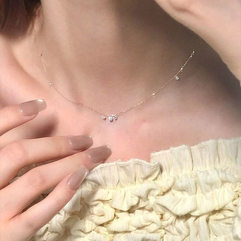 Close-up of the delicate chain and sparkling pendant of the gold-plated necklace.