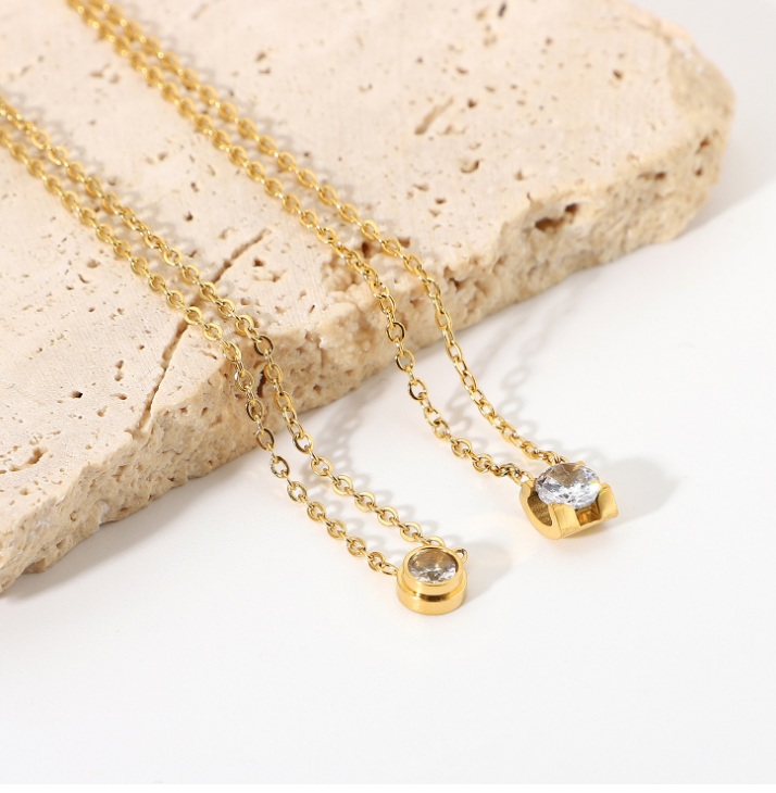The Delicate Round Solitaire Necklace shown in both gold and silver finishes
