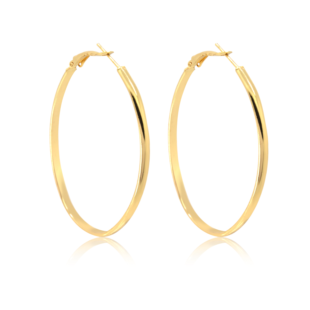 A model wearing the Gold Oval Hoop Earrings to show scale and style.