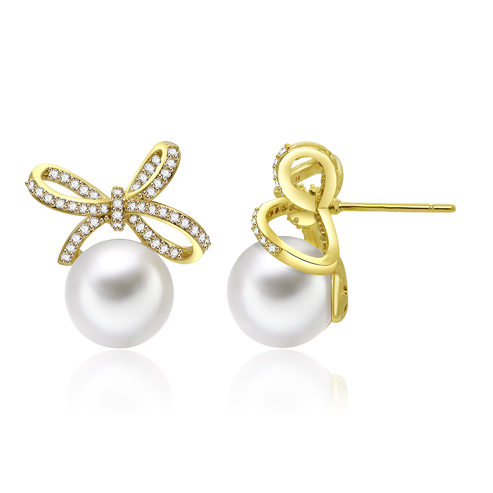 Detailed view of the gold bow and pearl on the stud earrings