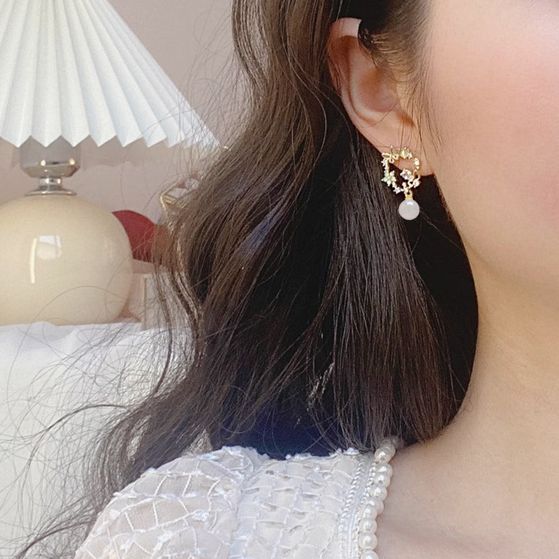 Model wearing the gold butterfly clip-on earring with a pearl drop.