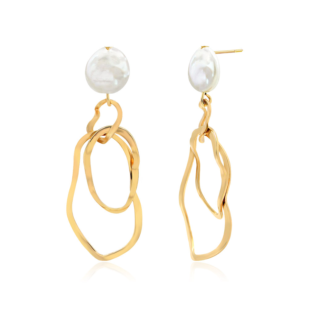 Detailed view of the gold pearl earrings with chain-like dangling structures