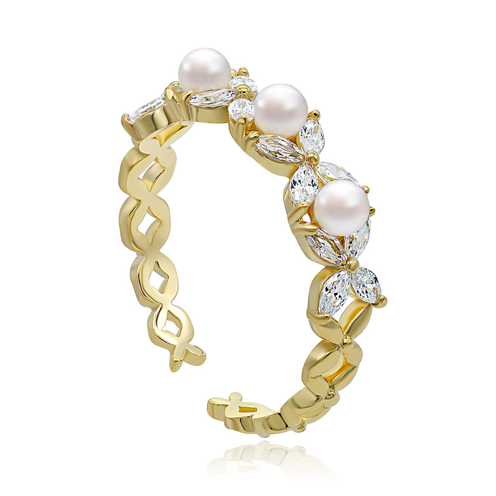 Detailed view of the Triple White Pearl and CZ Ring on a reflective surface