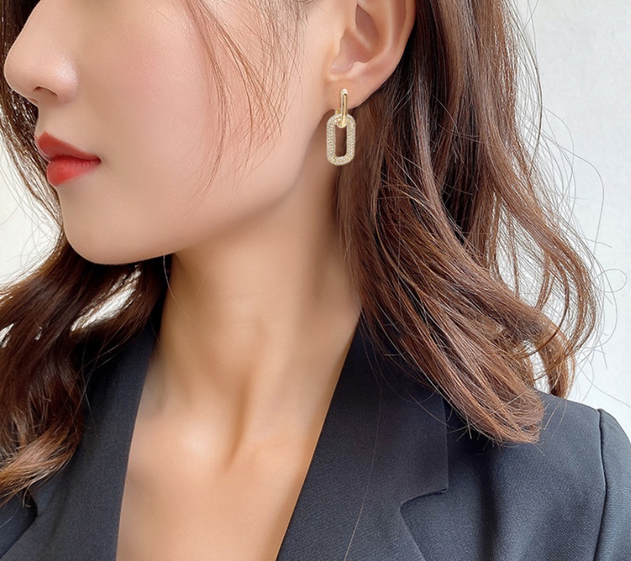 A model showcasing the elegant fit of the Gold Dangle Huggie Earrings.