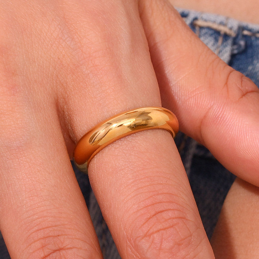 A close-up view of the 5mm gold stainless steel band ring being worn.