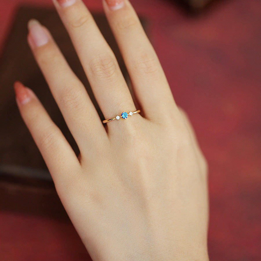 A woman wearing the gold-plated 925 sterling silver September birthstone ring.