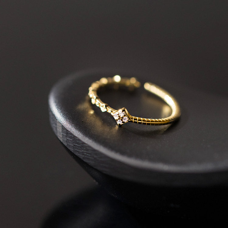 Detailed product view of the gold adjustable ring on a display