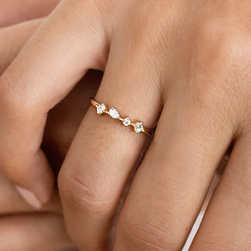 A woman wearing the 925 sterling silver four-zircon stacking ring on her middle finger