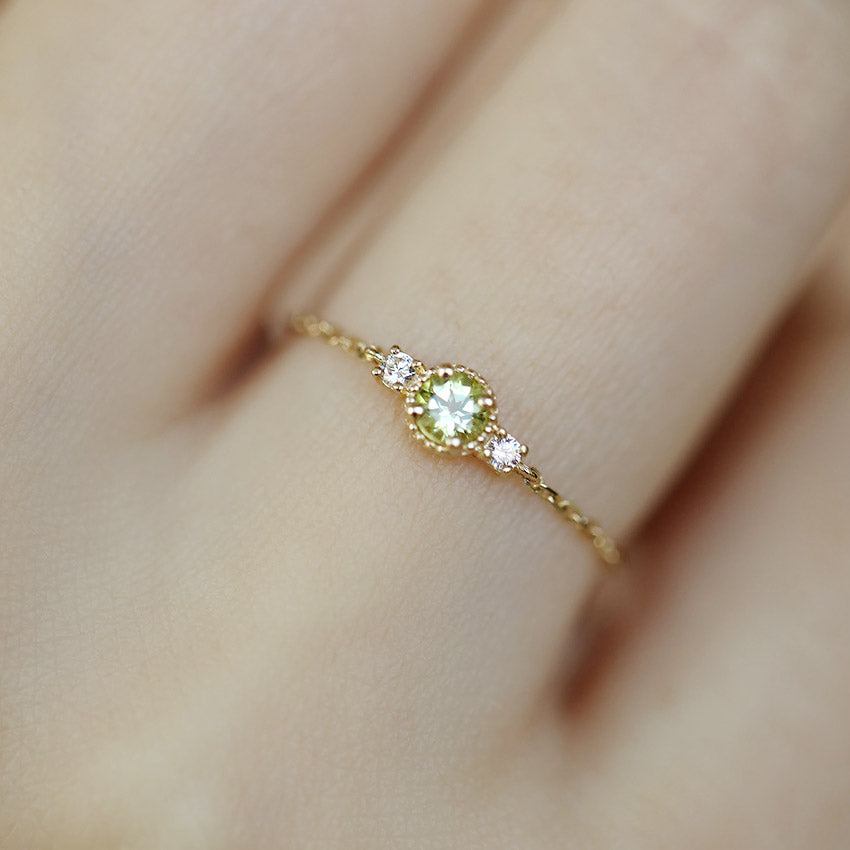 A woman's hand wearing the adjustable olivine zirconia birthstone ring