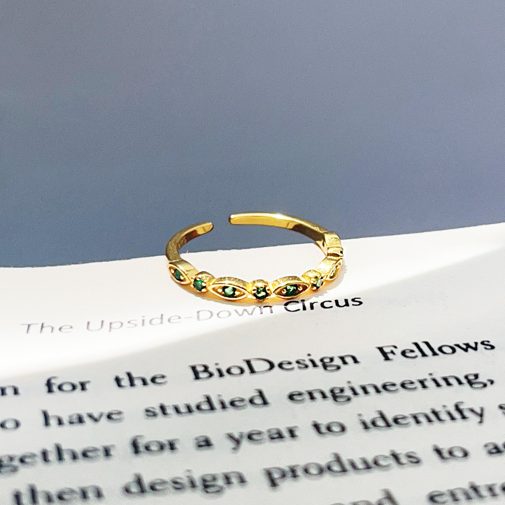 A detailed close-up of the gold-plated green zircon stacking ring.