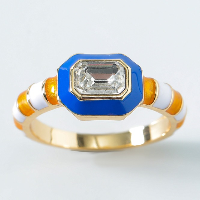 Detailed view of a gold ring with an octagonal gemstone and colorful enamel details
