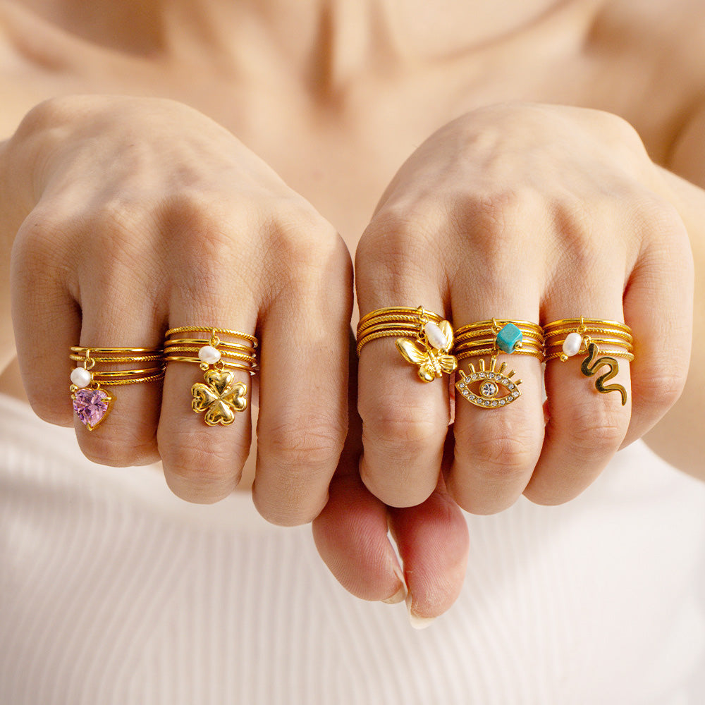 A model showcasing the 18K gold plated stainless steel charm rings on her hand.