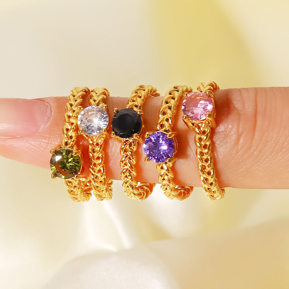 A collection of six gold rings with various colored gemstones.
