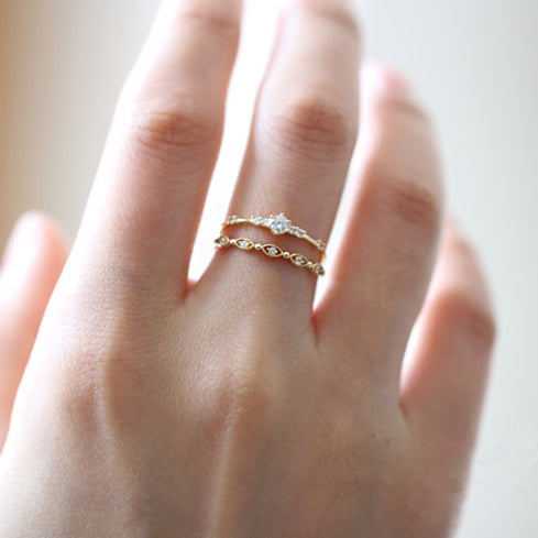 A model's hand showcasing the stackable 925 sterling silver zircon rings in a layered style.