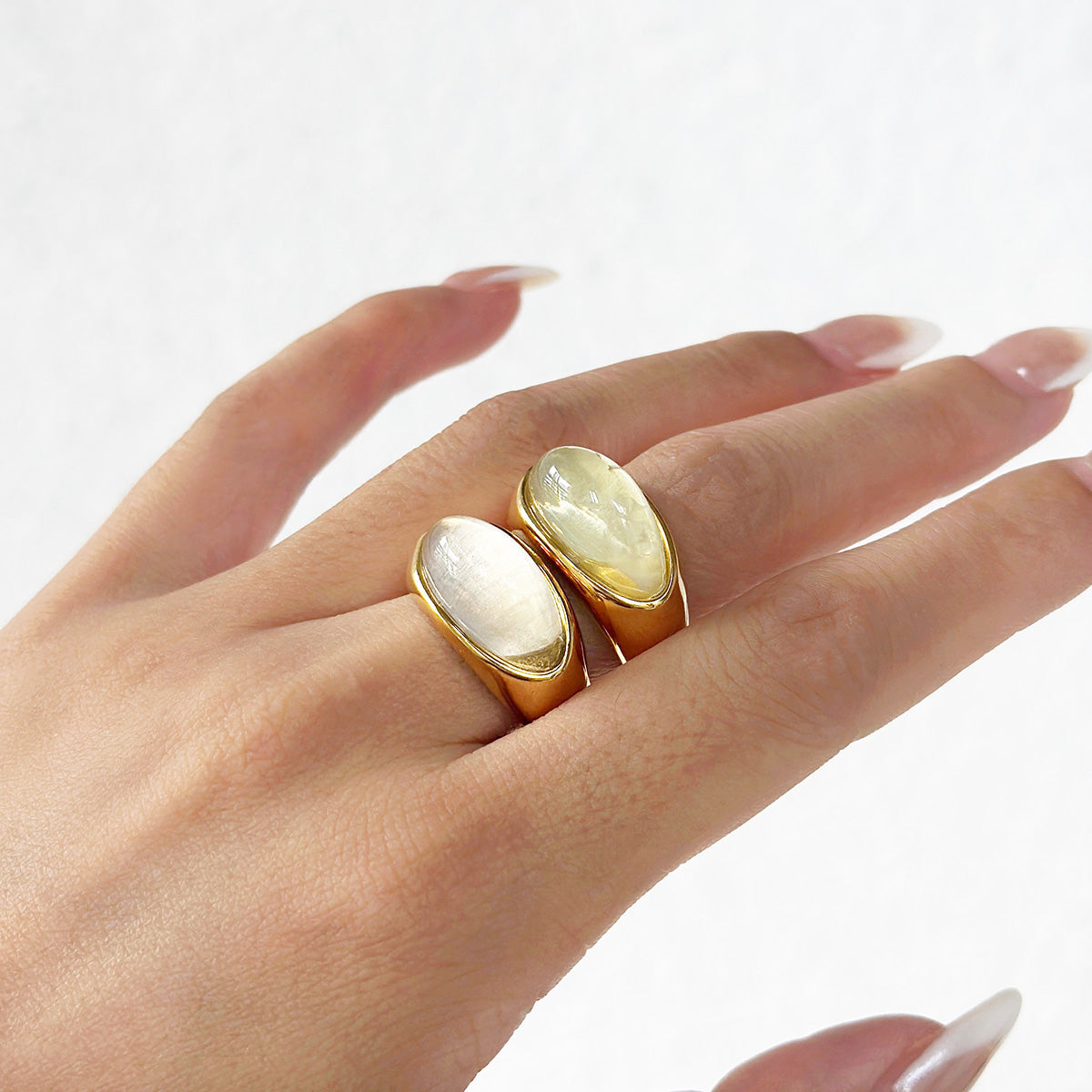 A pair of stainless steel rings with large oval opal stones