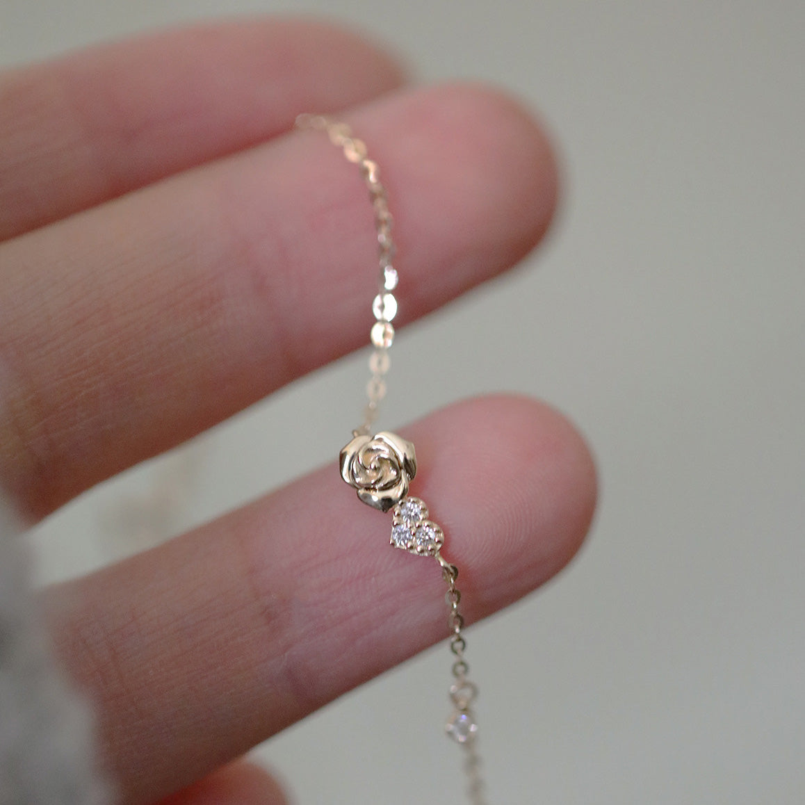 Detailed view of the rose charm on the 925 silver gold-plated bracelet