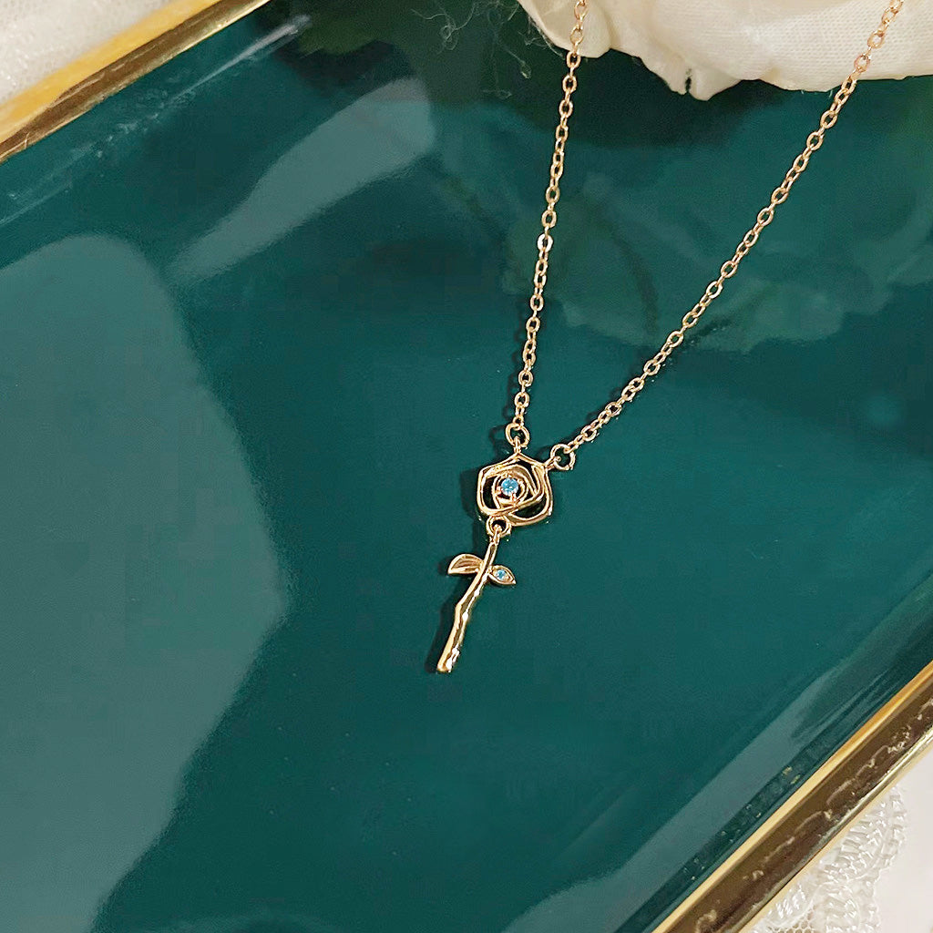 Detailed close-up of the gold rose pendant on a decorative tray
