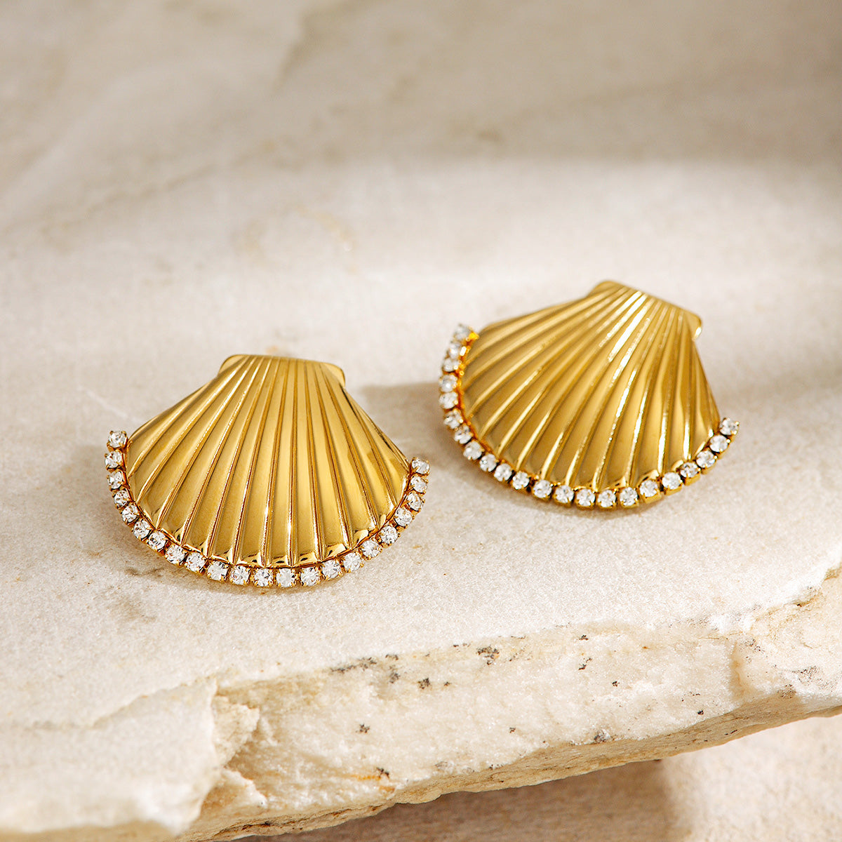 Detailed view of the gold CZ stone scallop shell stud earrings