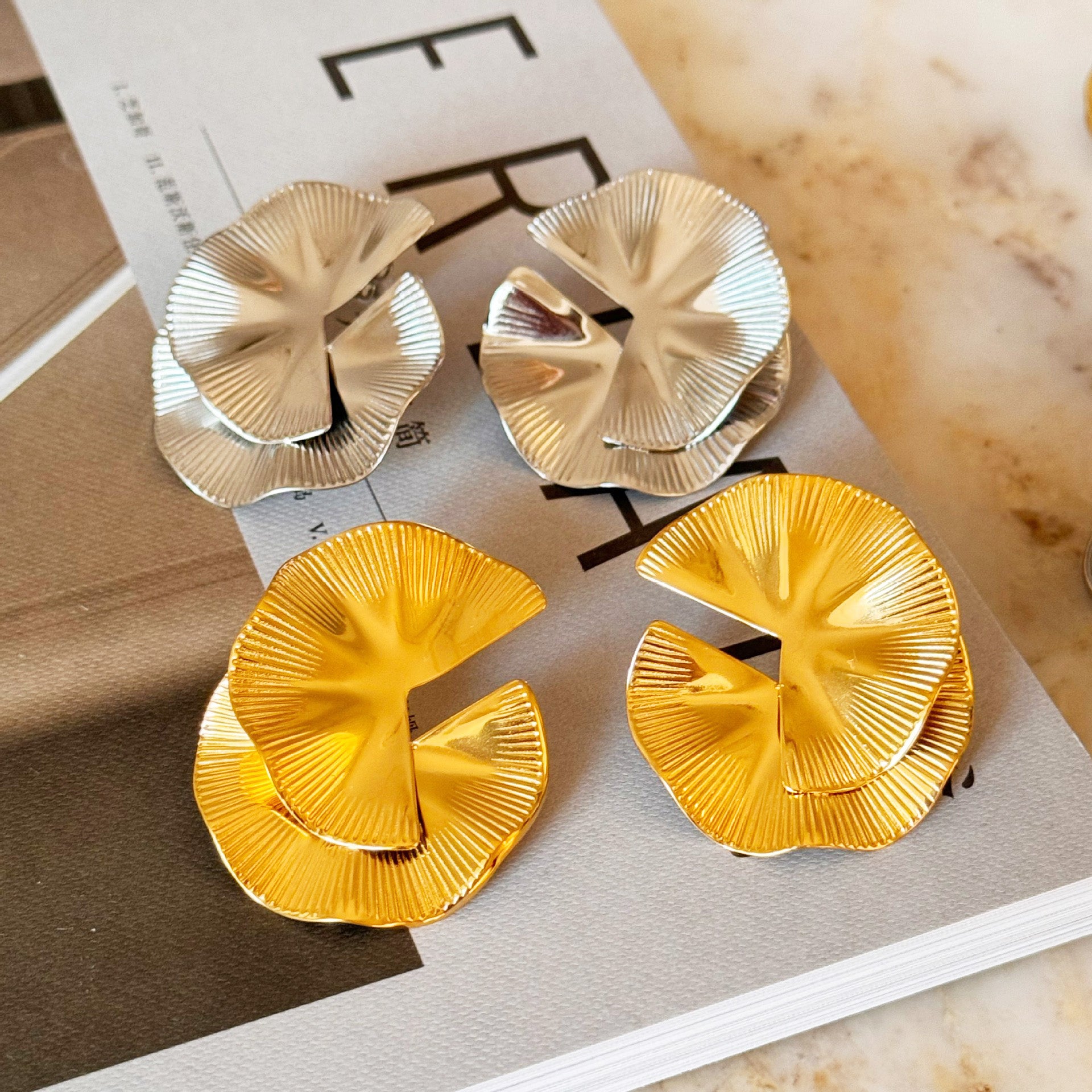 A collection of gold and silver flower-shaped statement earrings from the set