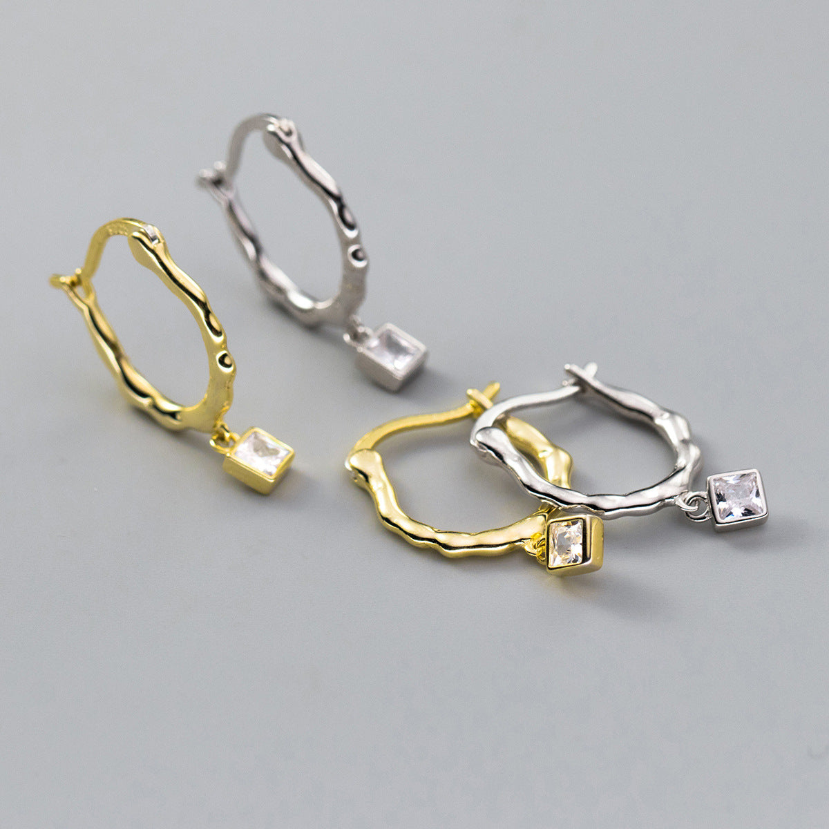 Twisted square-cut zircon earrings available in both gold and silver finishes