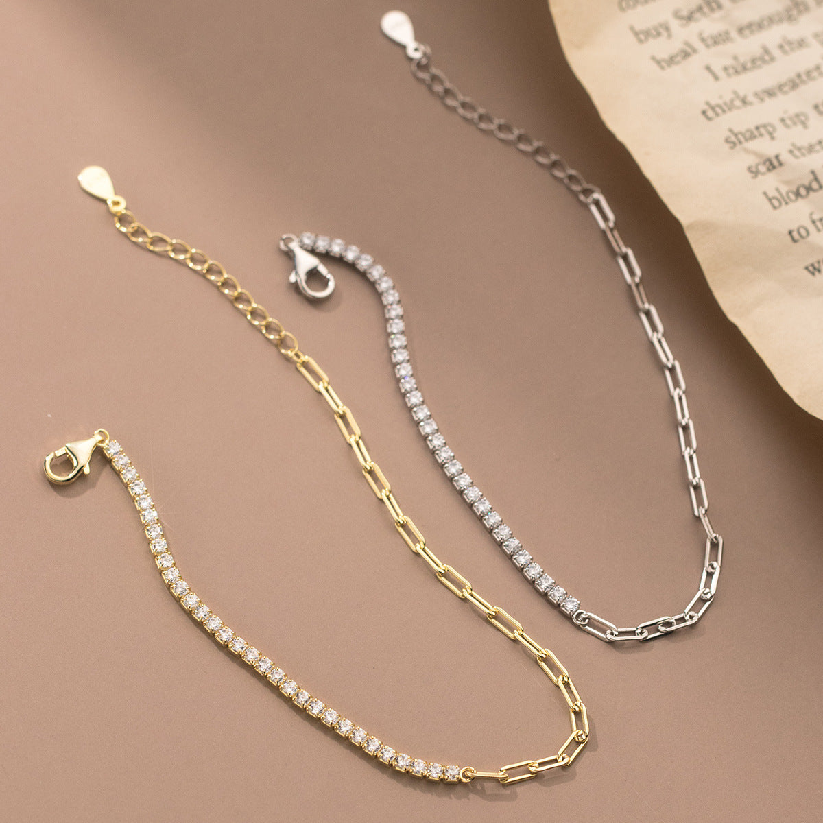 A pair of 925 sterling silver bracelets, one in a gold finish and one in a silver finish, both featuring a row of sparkling zircon stones on a link chain.