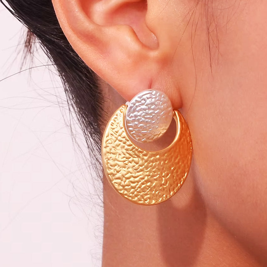 Close-up of the hand-hammered texture on the two-tone stainless steel earrings
