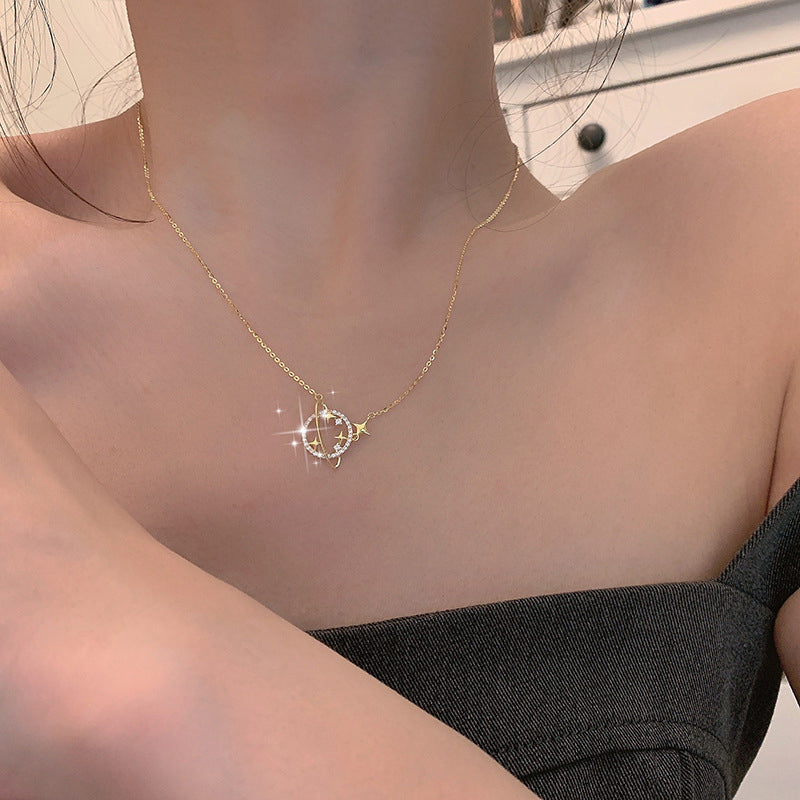 A gold necklace with a solar system pendant showcased on a neutral background