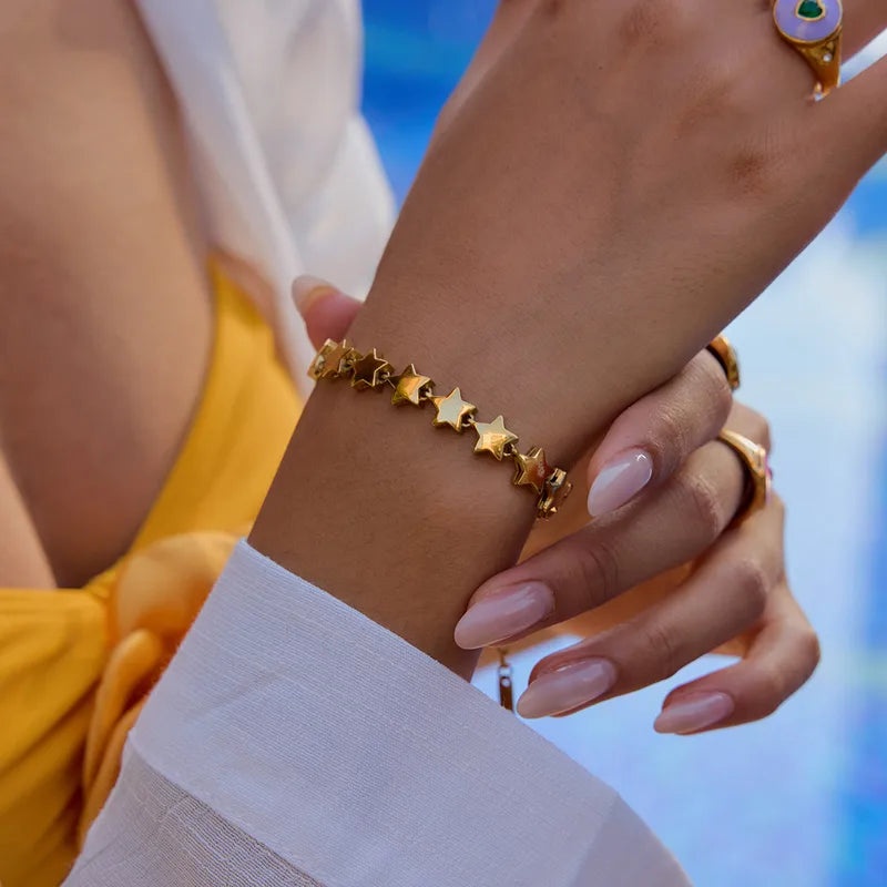 A woman's hand showcasing the elegant gold star bracelet