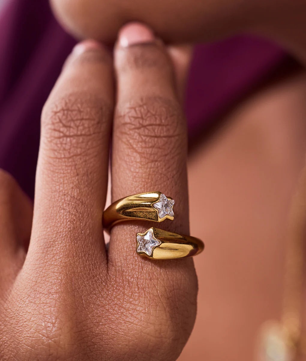 A model's hand showcasing the stacked look of the adjustable gold star rings.