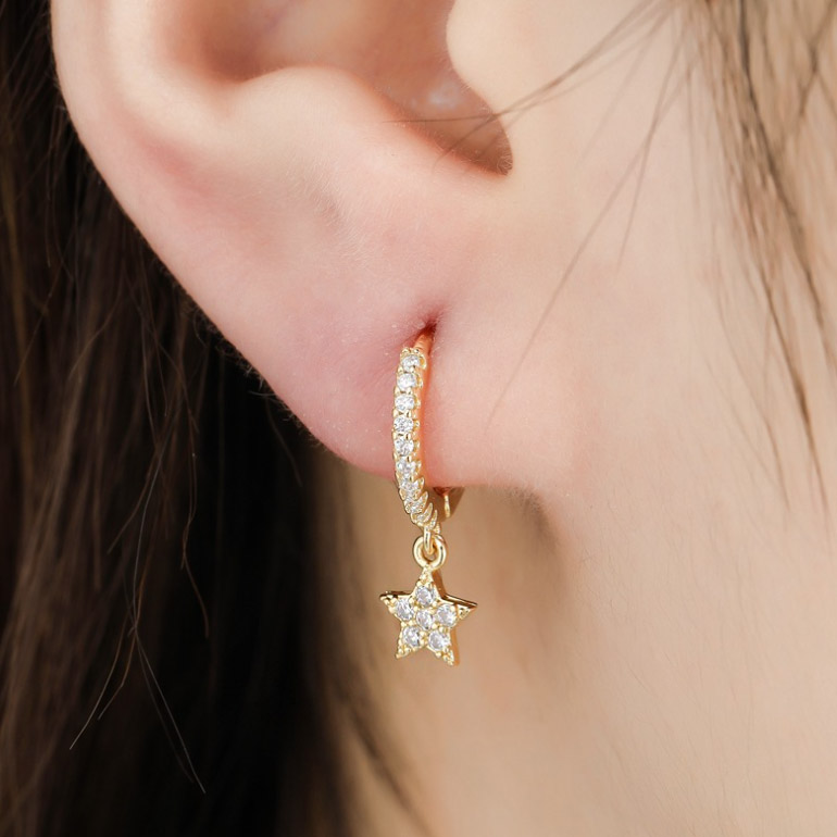 Close-up of the gold star huggie earring with cubic zirconia