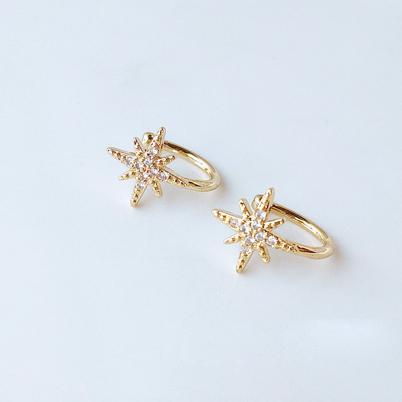 Detailed view of the 14k gold plated starburst ear cuff with clear gemstones