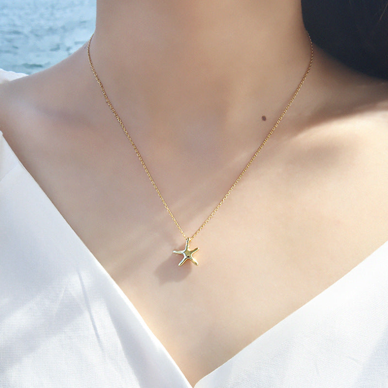A model elegantly wearing the gold starfish necklace, highlighting its delicate design.