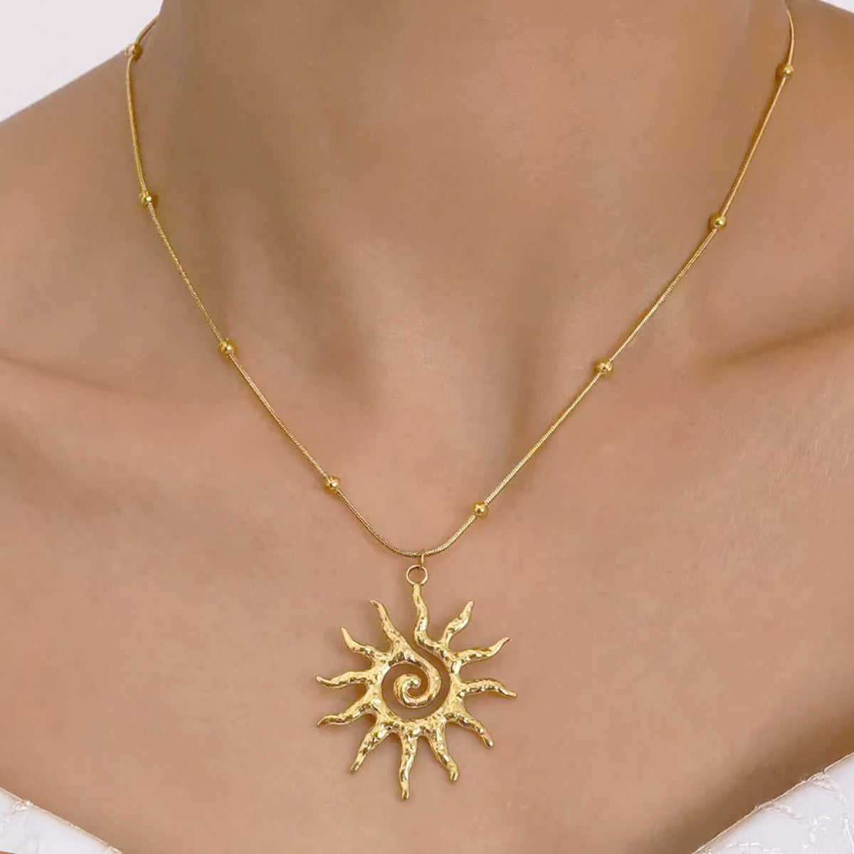 A woman wearing the 18k gold plated sun pendant necklace, showcasing its elegant look for summer.