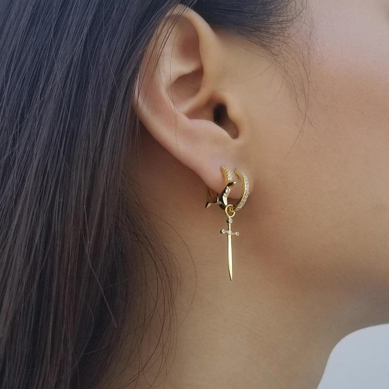 Model showcasing the gold sword drop hoop earring