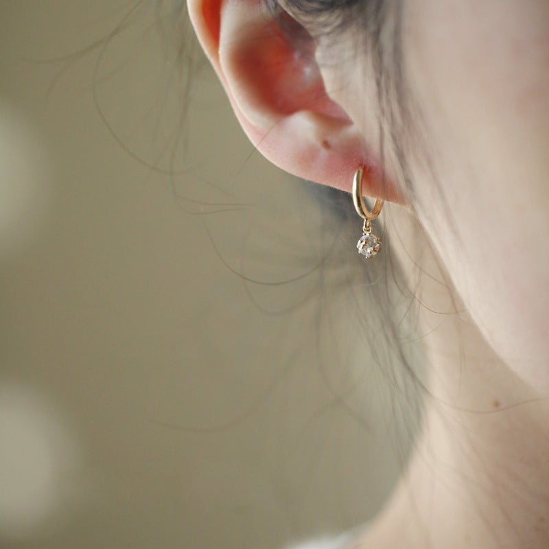 Model wearing a gold teardrop crystal earring from the 925 silver set