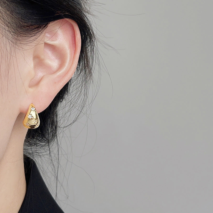 A model showcasing the elegant 14k gold-plated teardrop earring