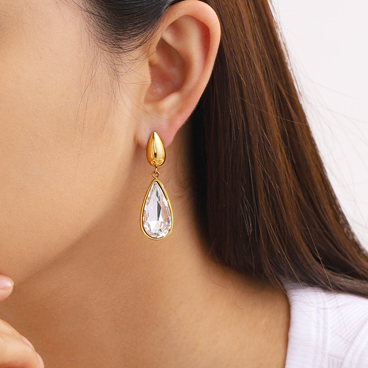 Detailed close-up of the gold teardrop earring's craftsmanship