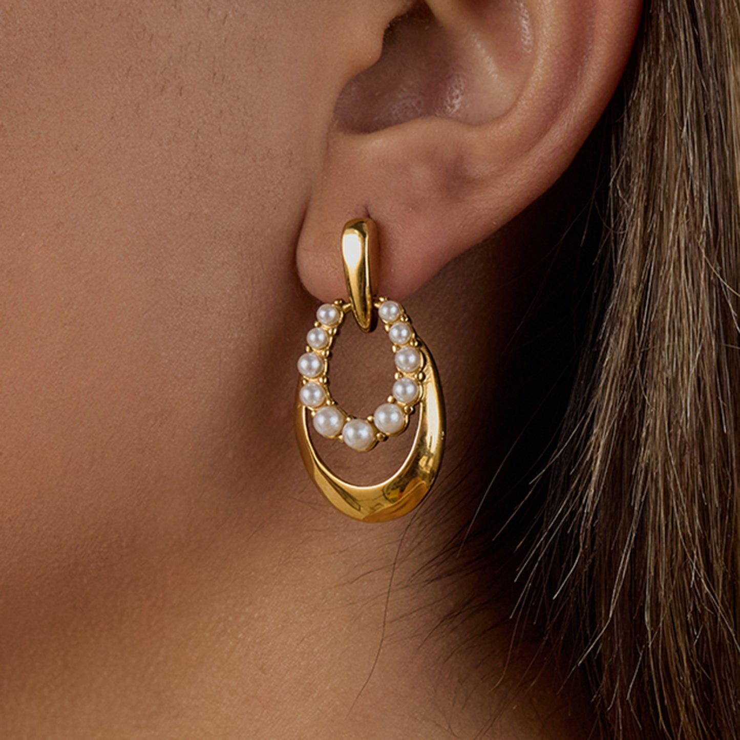 Close-up of PVD gold-plated earring with a pearl, showcasing its non-shedding design.