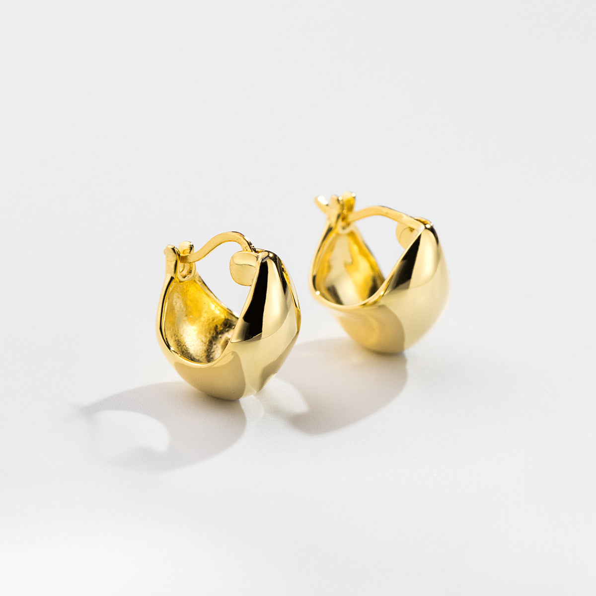 A pair of gold teardrop-shaped S925 sterling silver huggie hoop earrings
